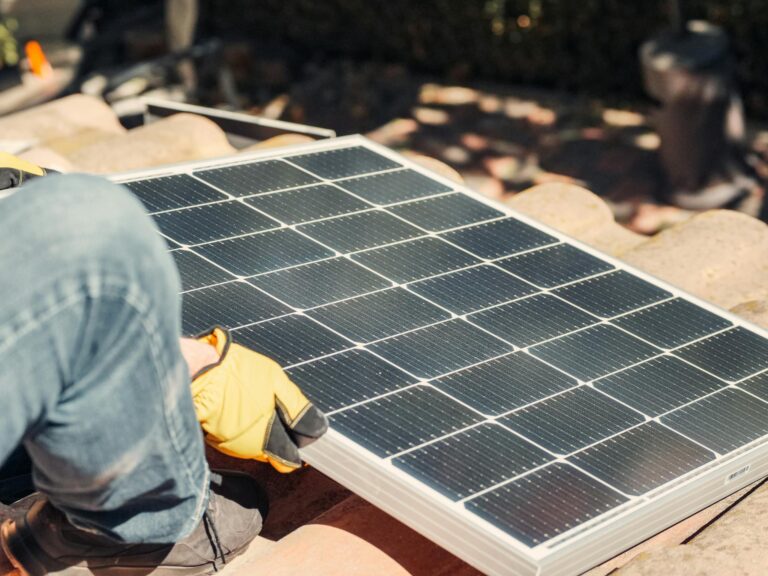a worker installs a solar panel on a sunlit rooftop exemplifying renewable energy. 9875423 2048x1536.jpg