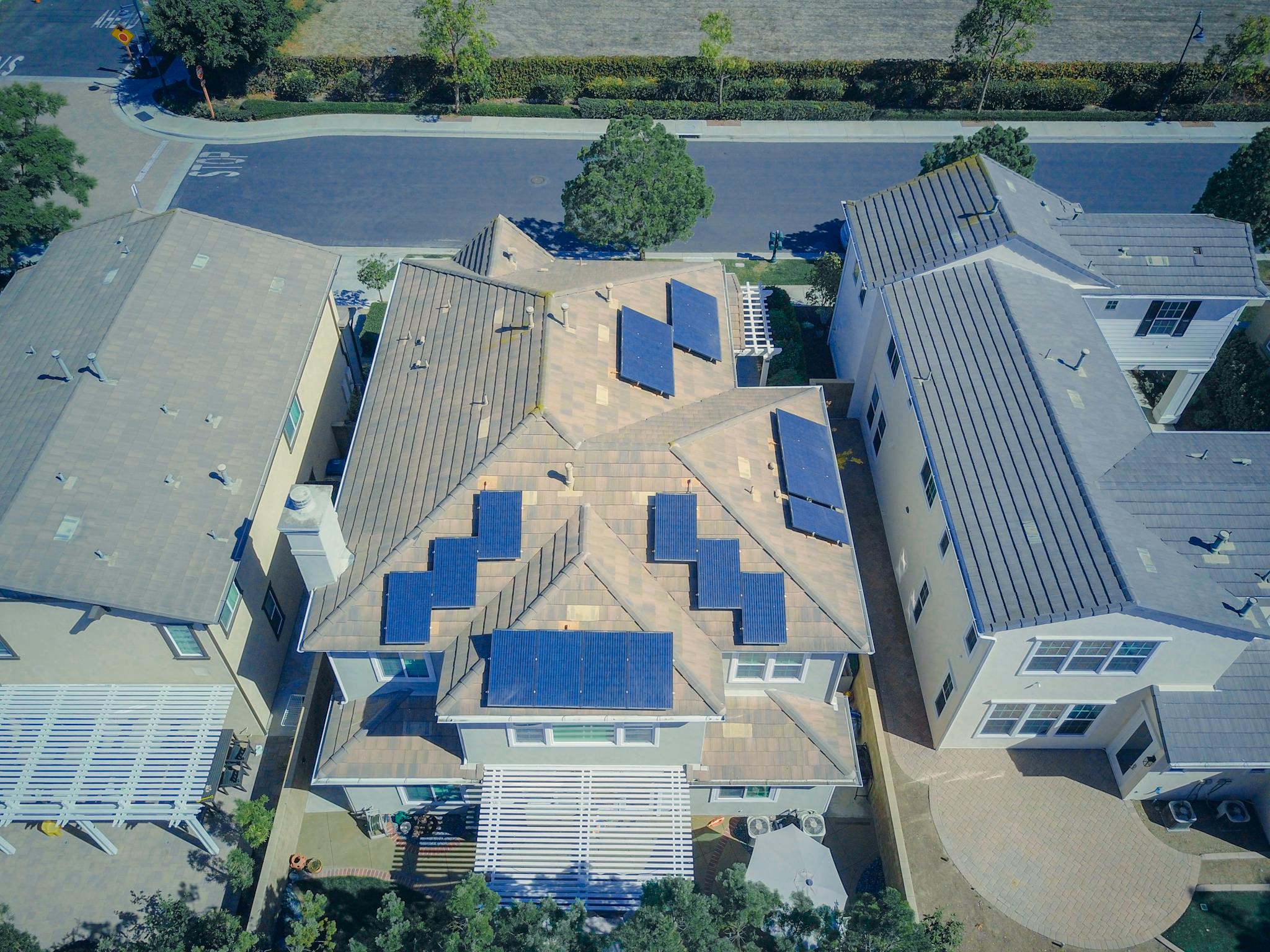 About Aerial view of suburban homes equipped with solar panels in a sunny neighborhood.