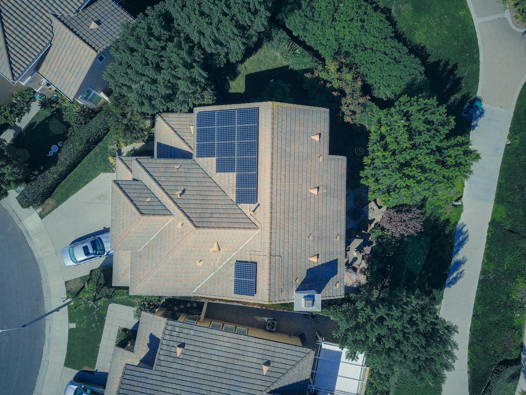 Services Top-down aerial view of a house with solar panels, showcasing modern renewable energy solutions.